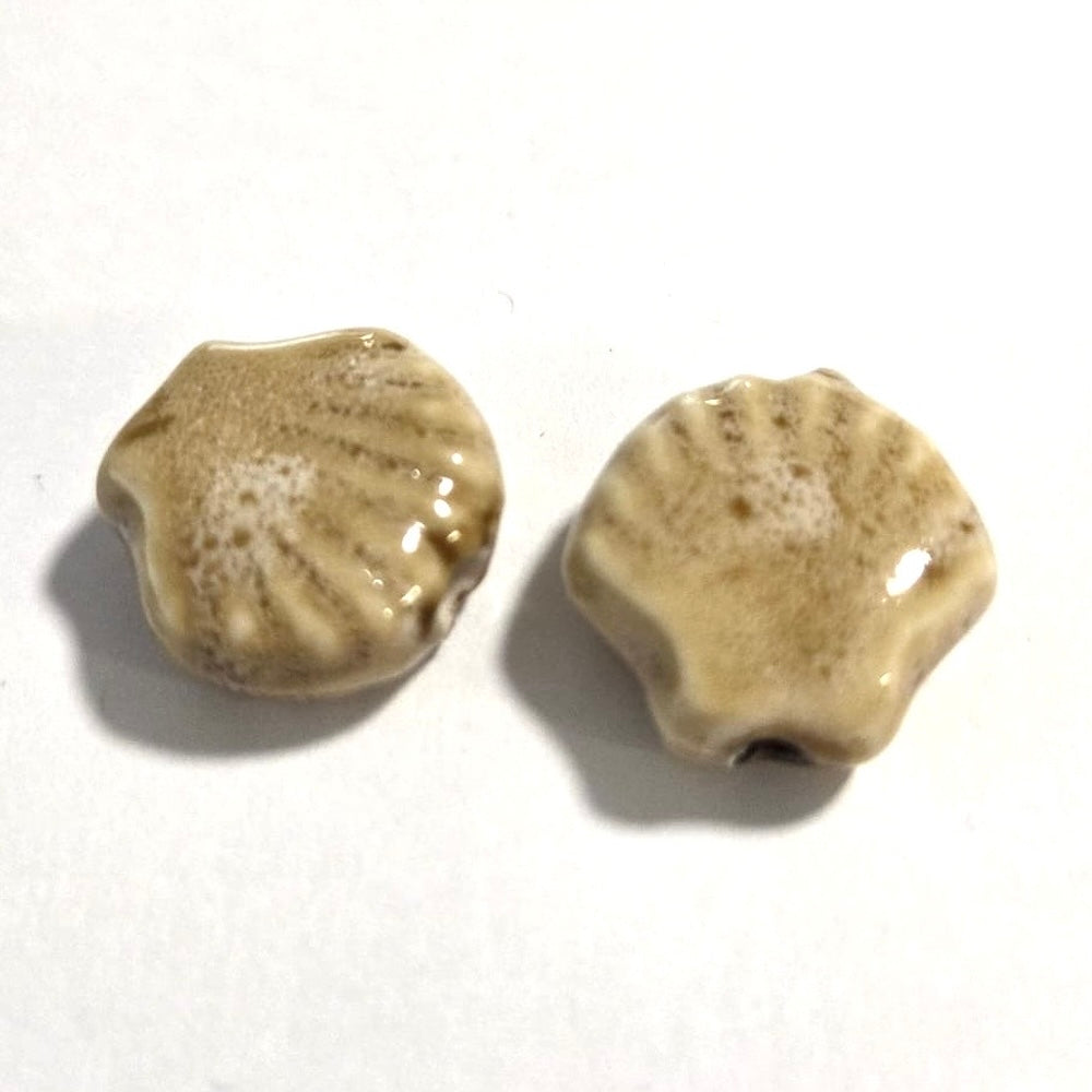 Two ceramic shell-shaped beads on a white background