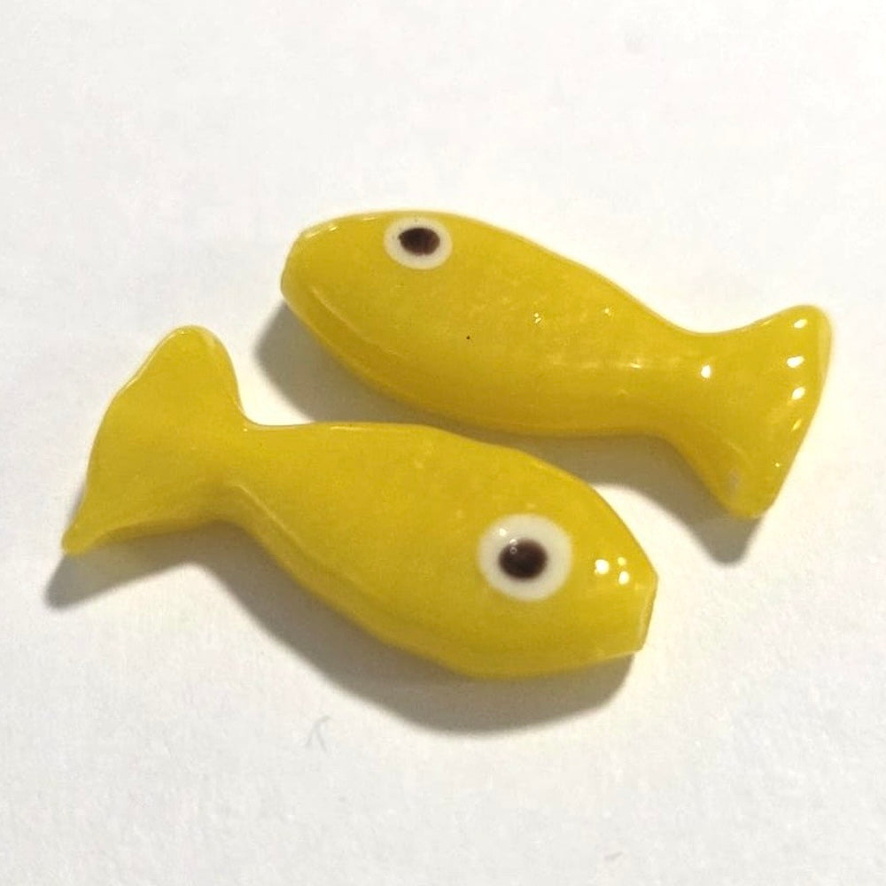 Two yellow fish-shaped objects on a white background
