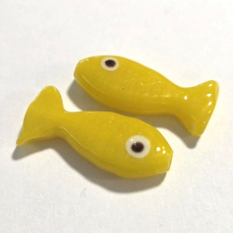 Two yellow fish-shaped objects on a white background