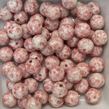 Marbled pink and white beads in a white container
