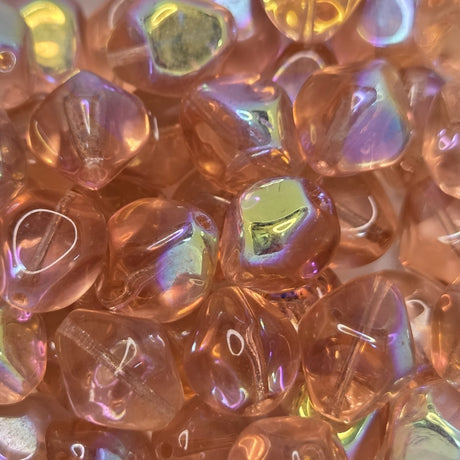 Close-up of transparent pink beads with shiny coating on parts of the surface