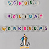 alphabet letter beads arranged on a white surface saying school holiday workshops with a Bead Shack logo