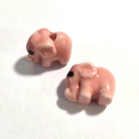 Two small pink elephant figurines on a white background