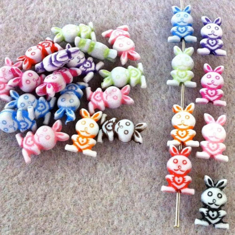 A collection of multicolored acrylic bunny rabbit beads scattered on a surface.