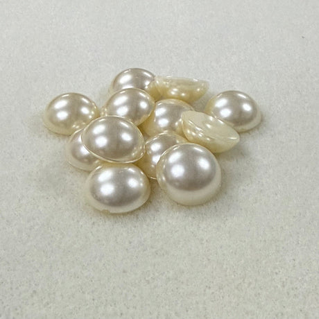Vintage pearl flat back cabochons on a beige surface