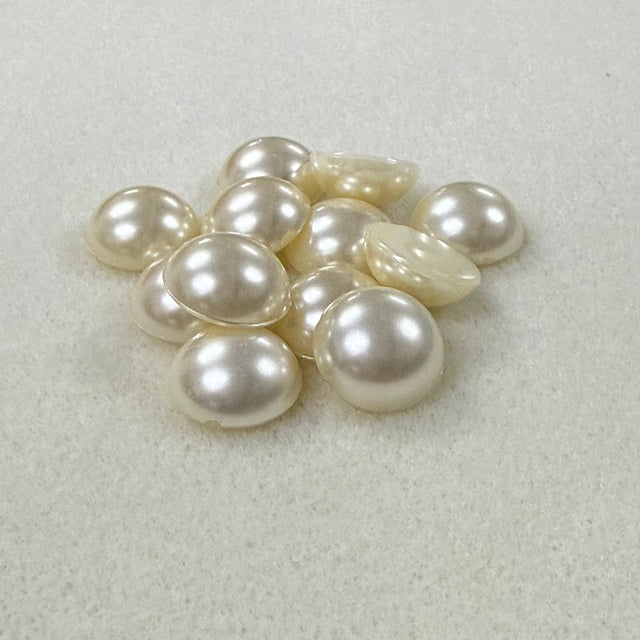 Vintage pearl flat back cabochons on a beige surface
