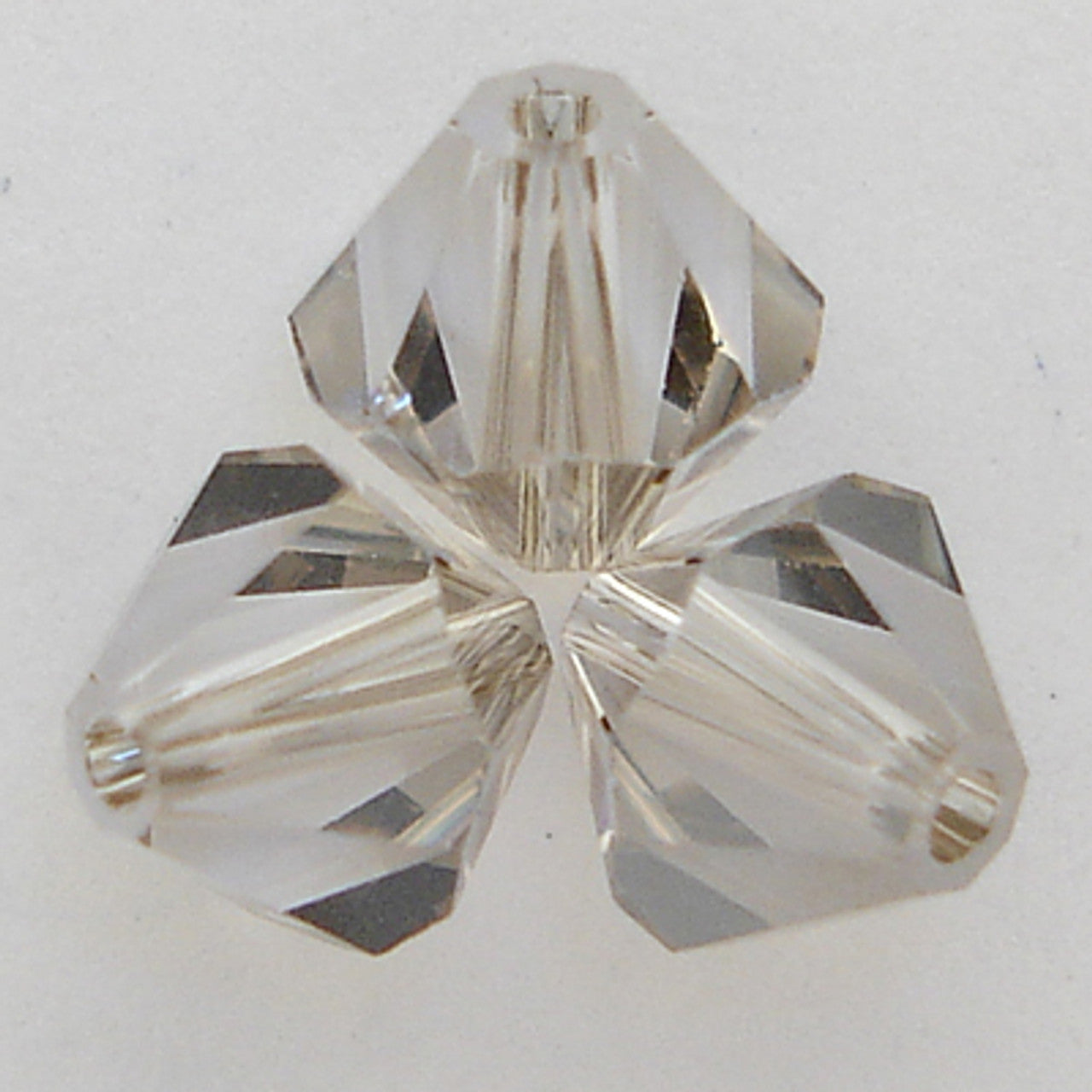 Three grey faceted crystal beads on a white background