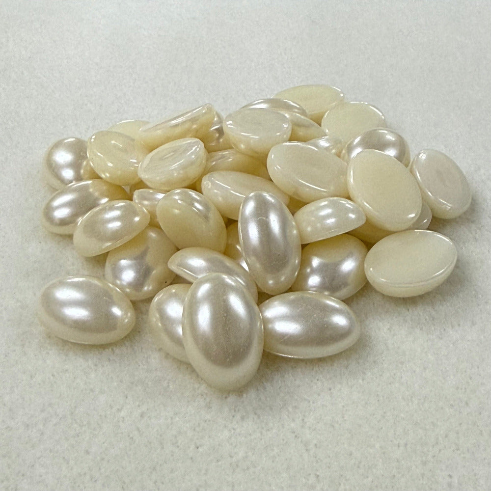 Vintage pearl flat back cabochons on a beige surface