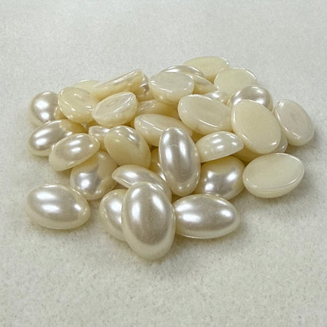 Vintage pearl flat back cabochons on a beige surface