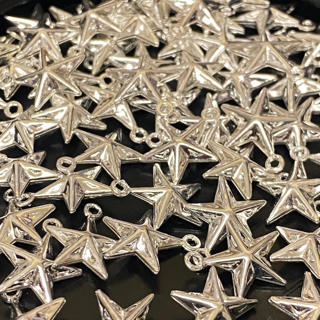 Collection of silver star-shaped pendants on a dark background