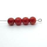 Four red beads on a white background