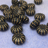Black beads with gold patterns on a light blue background