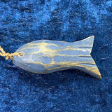 A hand-painted, hand-carved wooden fish decoration in navy and blue colors with shabby chic style, displayed on a blue textured background.