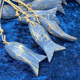 Wooden fish ornaments with gold accents on a blue textured background