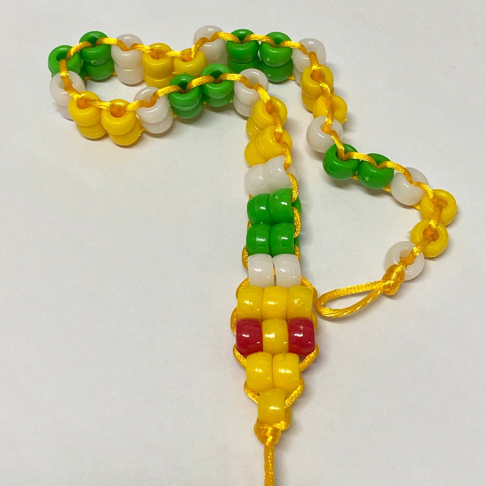 Colorful beaded bracelet with yellow, green, and white beads on a light gray background