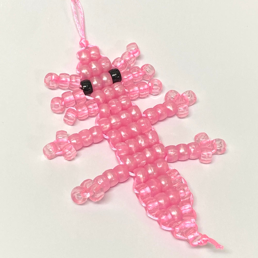 pink beaded axolotl toy on a white background