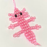 pink beaded axolotl toy on a white background