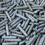 Close-up of a pile of blue cylindrical vintage ceramic beads with intricate patterns.