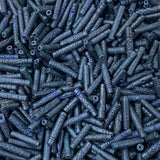 Close-up of a pile of dark blue cylindrical vintage ceramic beads with intricate patterns.