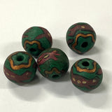 Five green and brown patterned vintage ceramic beads with lizards on a white background