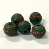 Five green and brown vintage ceramic patterned beads on a white background