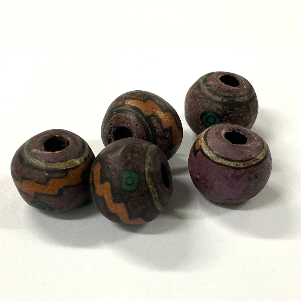 Five rustic beads with brown, purple, and green patterns on a white background