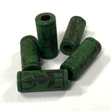 Green cylindrical beads with black peruvian patterns on a white background
