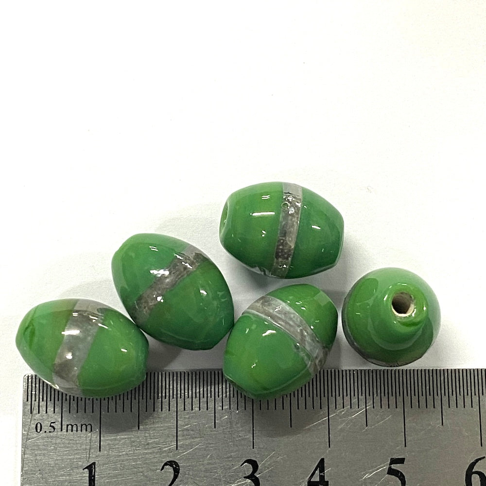 Green beads with silver stripes on a white background, measured against a ruler.