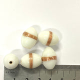 White beads with gold stripes on a white background with a ruler for scale.