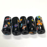 Set of six black cylindrical beads with colorful designs on a white background