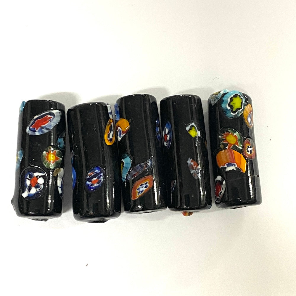 Set of five black cylindrical beads with colorful designs on a white background