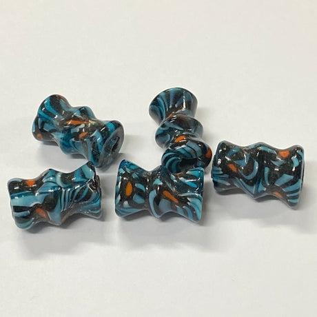Five blue and black patterned beads on a white background