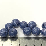 Blue speckled beads with a ruler for scale on a white background