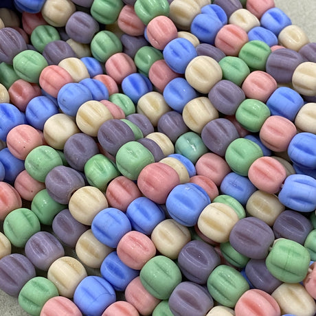 Colorful glass pastel beads on a textured surface