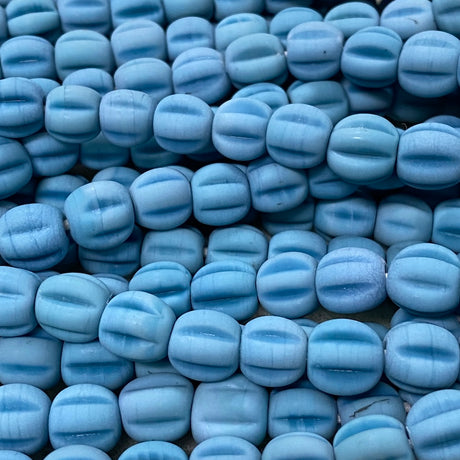 Close-up of blue glass melon shaped beads with a blurred background
