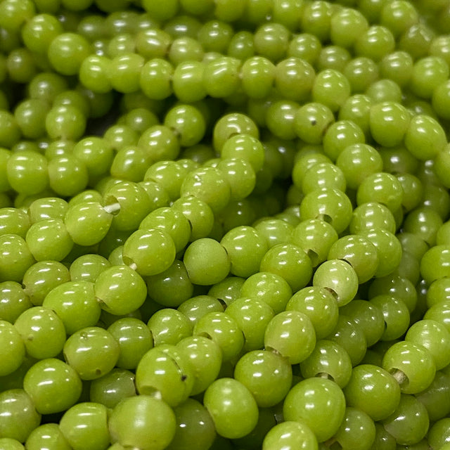 Close-up of small green beads on a string