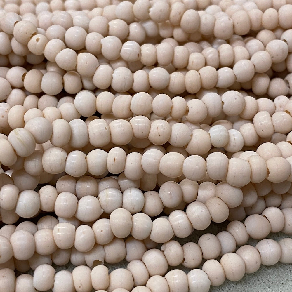Close-up of small cream beads on a gray surface