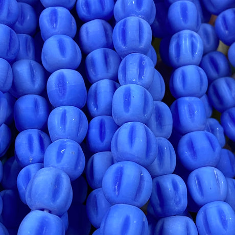 Close-up of blue glass melon shaped beads with a blurred background