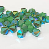 faceted green crystal beads on a white background