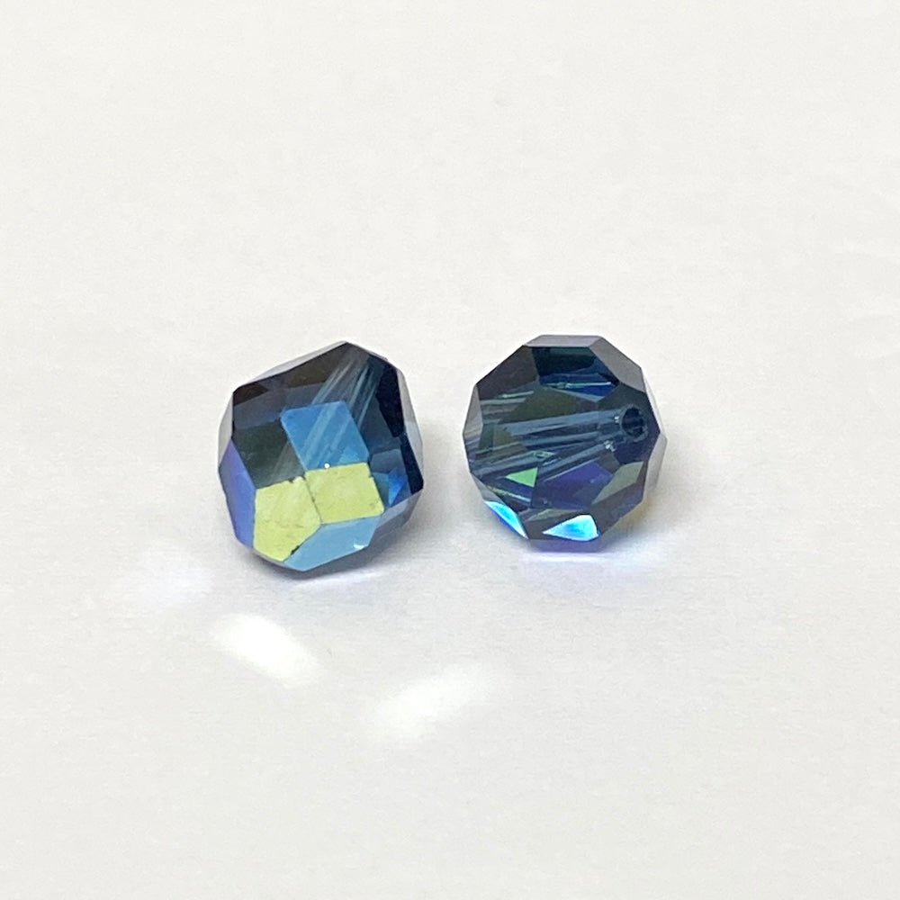 Two faceted blue crystal beads on a white background