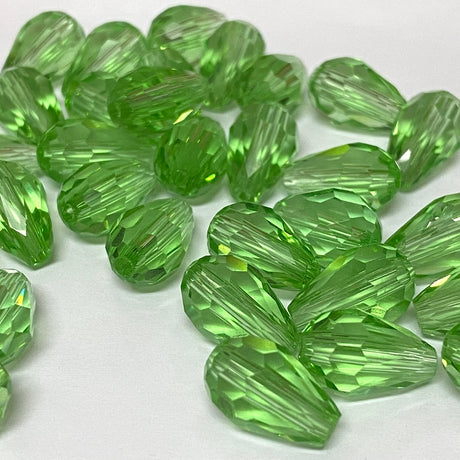 Green faceted crystal pear shaped drop beads on a white background