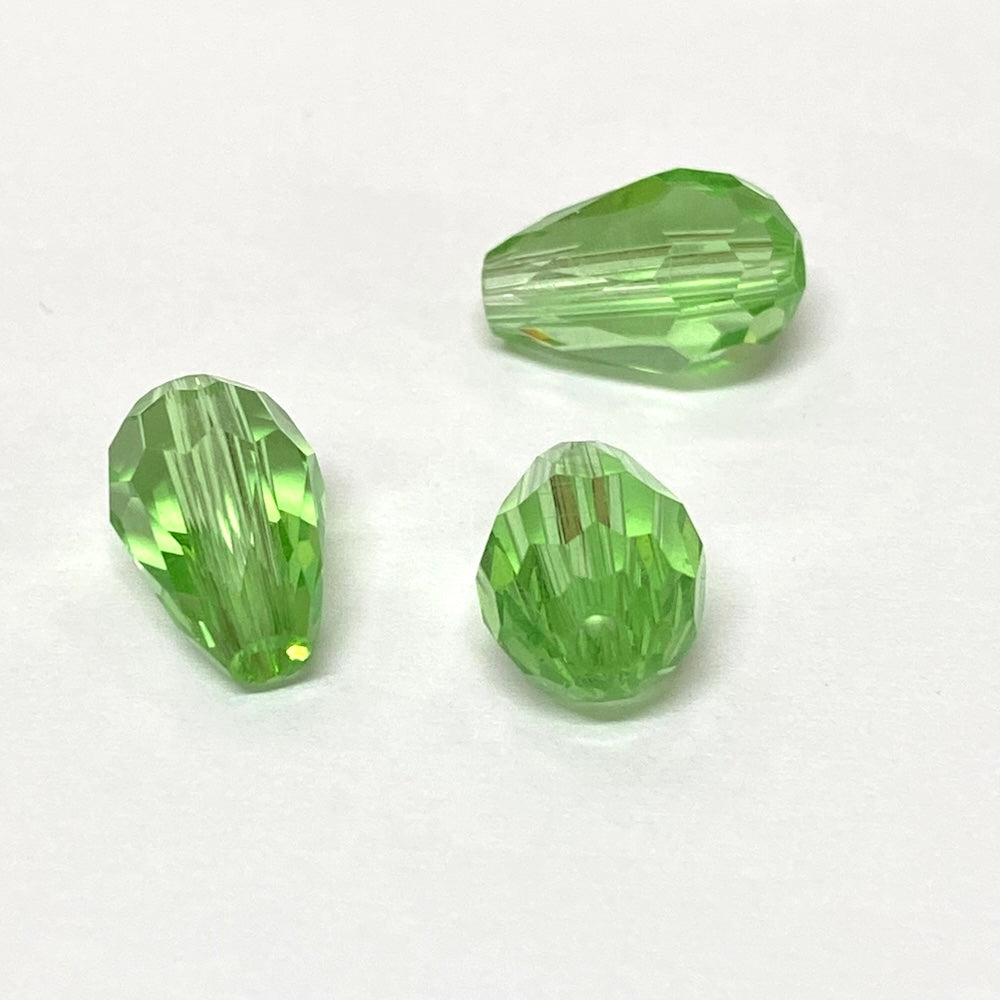 Green faceted crystal pear shaped drop beads on a white background