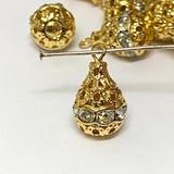 Group of gold and crystal pear shaped pendant beads on a white background