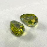 Green faceted crystal pear shape  bead on a white background
