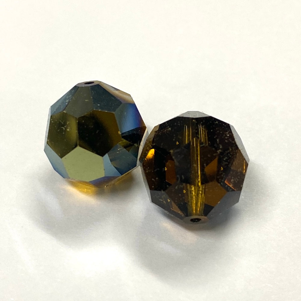 Two faceted brown crystal beads on a white background