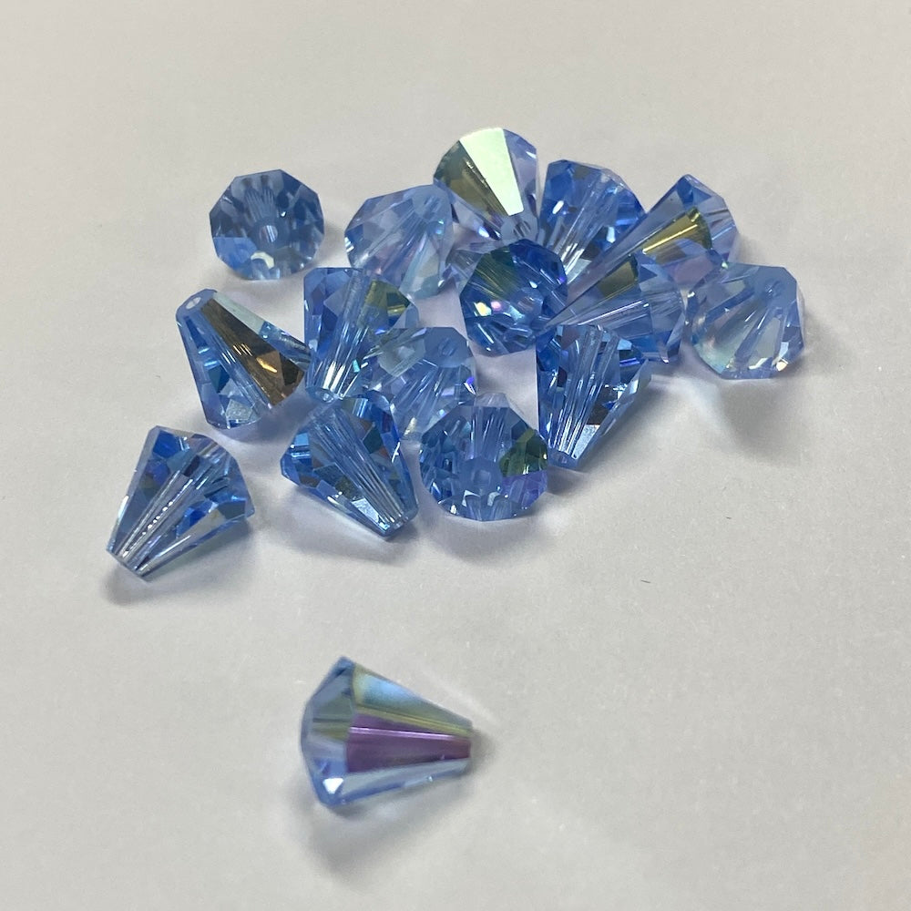 Blue faceted crystal bell shape beads on a white background