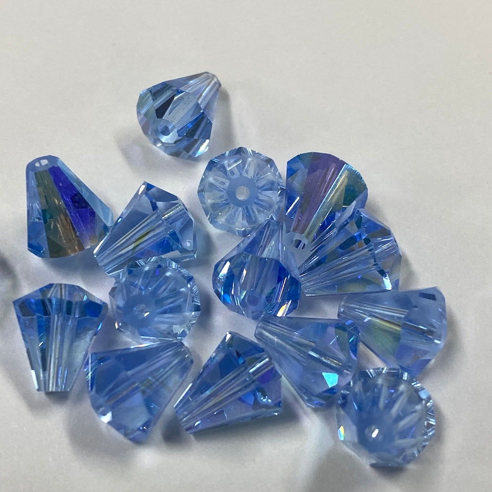 Blue faceted crystal bell shape beads on a white background