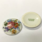 Two ceramic vintage discs, one with floral design and 'Limoges France' text on the other.