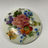 Round ceramic tile with floral design on a white background