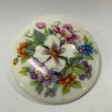 Round ceramic tile with floral design on a white background